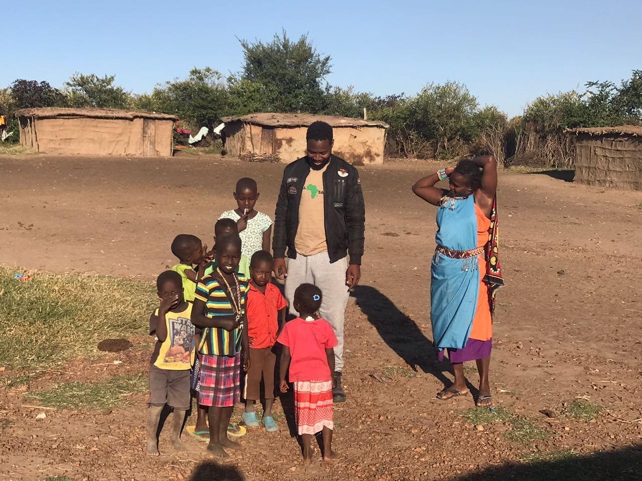 Reuben with children and a Maasai woman in the village